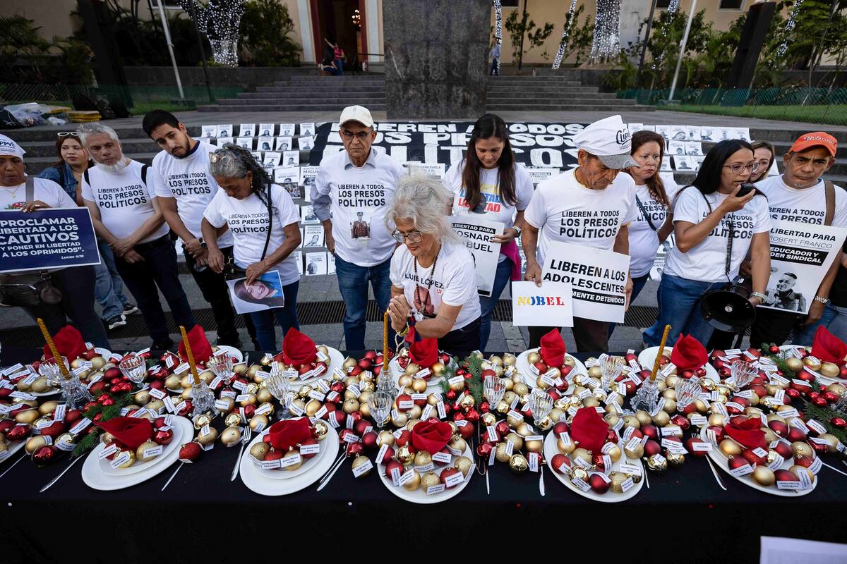 Familiares de presos políticos y activistas de derechos humanos participan en una manifestación en la que instalan una mesa navideña simbólica con los nombres de los detenidos para exigir su liberación, este domingo, en Caracas (Venezuela). EFE/ Ronald Peña R