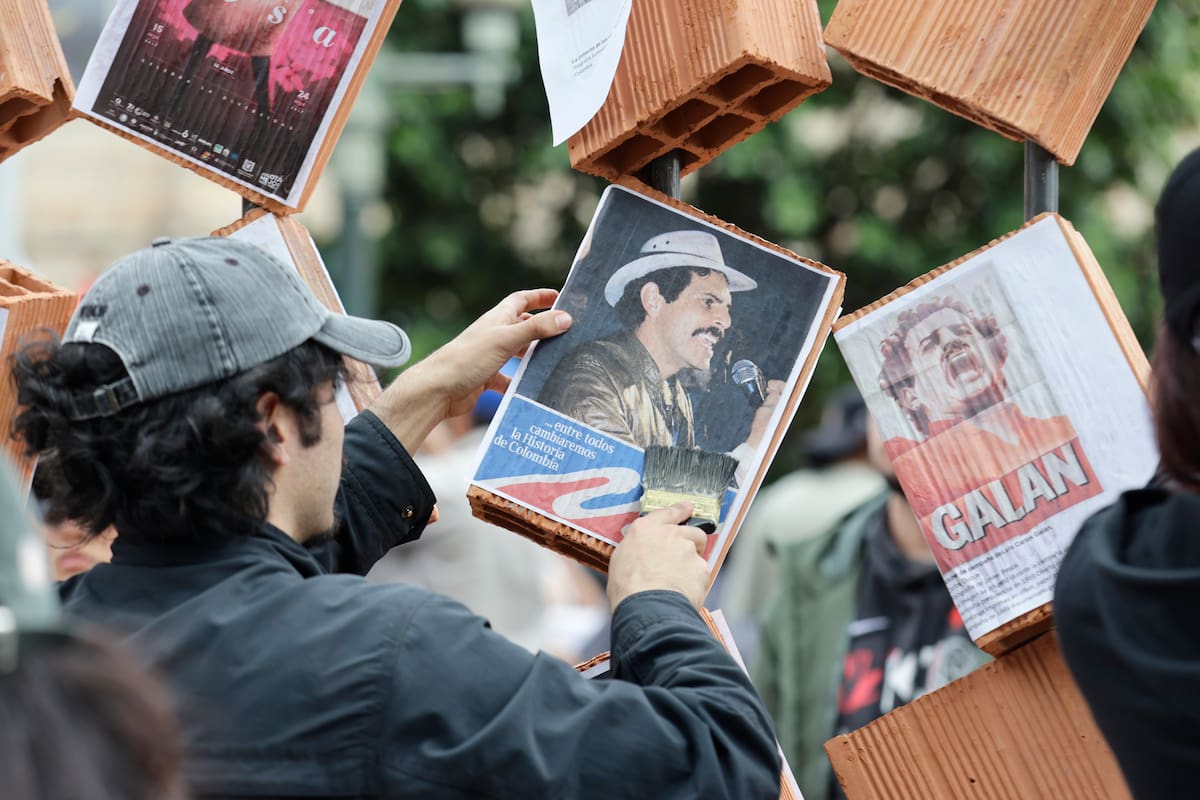 FOTODELDÍA AME7091. BOGOTÁ (COLOMBIA), 17/10/2026.- Un hombre pega carteles sobre la obra LATEREM, El Bloque Nos Une del artista Sergio Mendoza durante una protesta frente al Museo Nacional, este sábado en Bogotá (Colombia). La protesta se produjo después de que fueran retirados al menos 30 afiches, fotografías y objetos de tres salas del museo, relacionados con los movimientos feministas y LGBTI, las víctimas de la violencia política y el acuerdo de paz firmado en 2016 entre el Estado colombiano y las Fuerzas Armadas Revolucionarias de Colombia (FARC). EFE/ Carlos Ortega