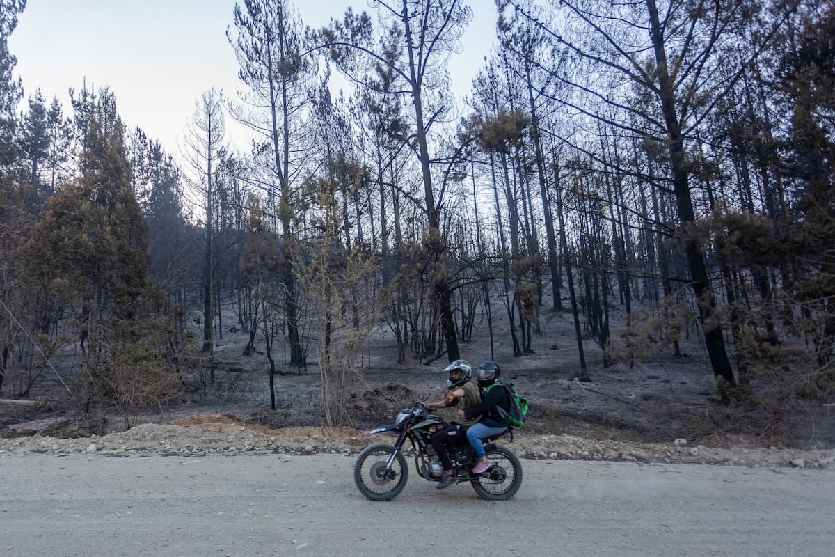 Personas pasan en motocicleta por una zona afectada por los incendios forestales este miércoles, en el Hoyo provincia de Chubut (Argentina). Los incendios forestales en la Patagonia argentina se continuaron expandiéndose en las provincias de Chubut, Santa Cruz y Río Negro y han dejado ya un saldo de más de 4000 hectáreas, según datos oficiales. EFE/ Matías Garay