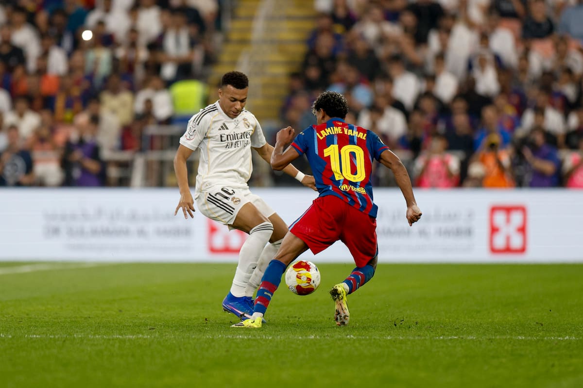 El delantero francés del Real Madrid, Kylian Mbappé, intenta superar al delantero del FC Barcelona, Lamine Yamal.EFE/ Kai Försterling