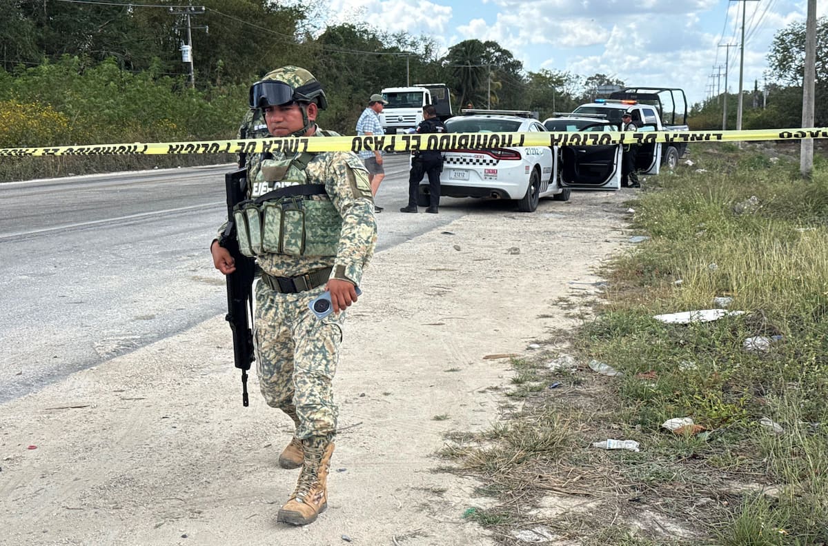 MEX5079. CANCÚN (MÉXICO), 22/02/2026.- Integrantes del Ejército de México custodian la zona donde un vehículo fue incendiado este domingo, en el balneario de Cancún en Quintana Roo (México). La Secretaría de la Defensa Nacional de México confirmó el abatimiento de Nemesio Rubén Oseguera Cervantes, alias El Mencho, líder del Cártel Jalisco Nueva Generación (CJNG), lo que ocasionó reacción del grupo criminal realizando bloqueos y quema de vehículos. EFE/Alonso Cupul