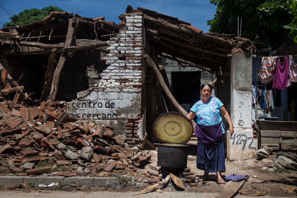 MEX05. JUCHITÁN (MÉXICO), 06/10/2017.- Una habitante del municipio de Juchitán, cocina junto a una vivienda destruida marcada con los folios que le permitirá acceder a los apoyos del gobierno para reconstruir su vivienda, en el estado de Oaxaca (México) hoy, viernes 6 de octubre de 2017. Peña Nieto recordó que los recursos que proporcione el Gobierno federal a la ciudad serán "iguales a los que están destinados a otras entidades" afectadas por los terremotos que golpearon duramente el sur del país. EFE/ Luis Villalobos