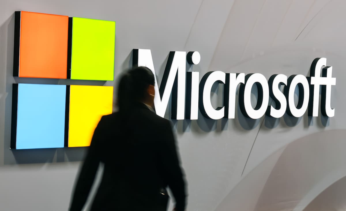 Fotografía de archivo que muestra a una mujer que pasa junto al logotipo de Microsoft. EFE/EPA/HANNIBAL HANSCHKE