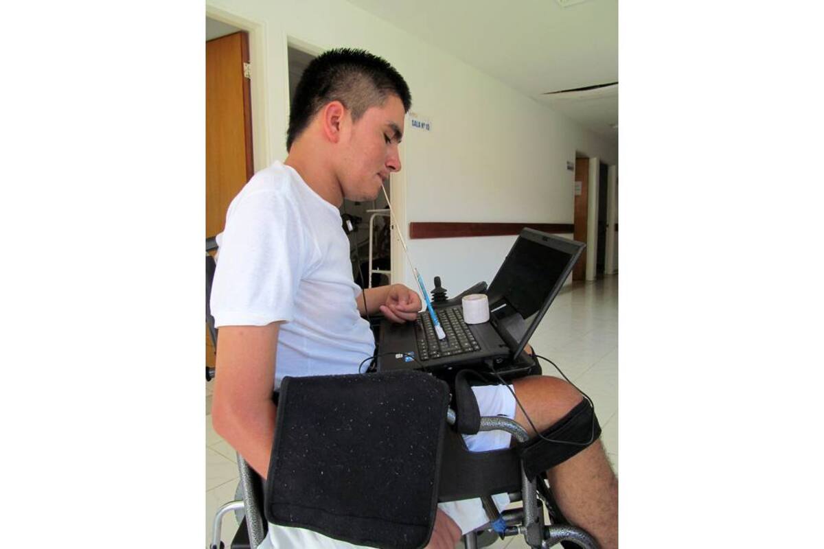 Usando la boca para escribir en el computador, el joven Miguel Agredo logró sacar su bachillerato adelante. (Foto: Suministrada / VANGUARDIA LIBERAL)