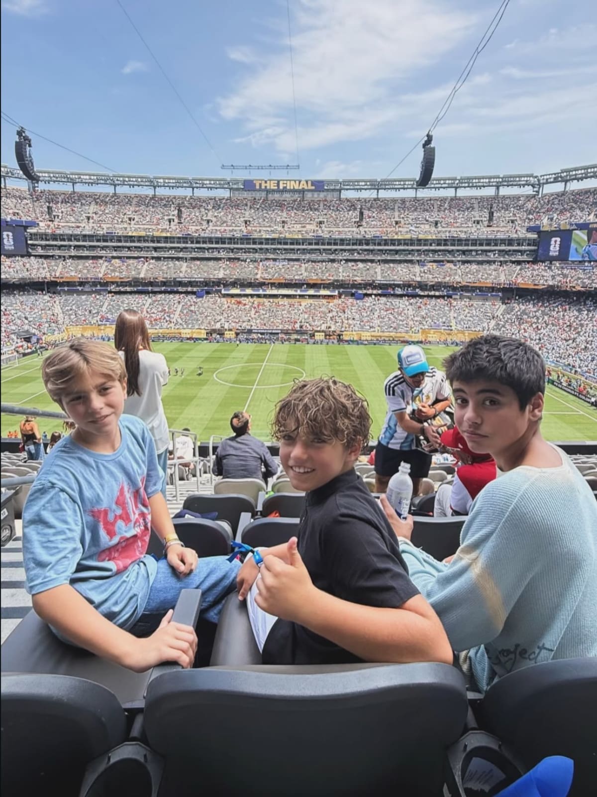 Milan y Sasha en el partido de argentina vs españa, esperando para ver a su mamá en el halftime show de la final del Mundial 2026.