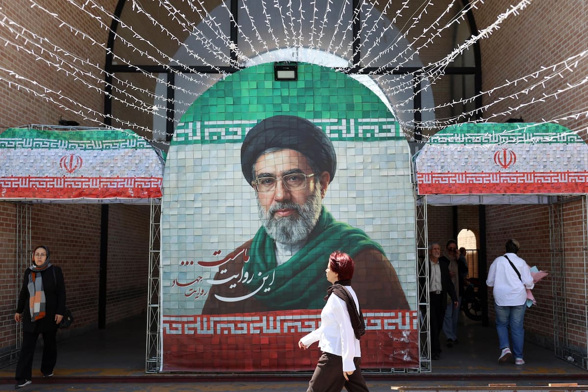 Iraníes caminan junto a una imagen del líder supremo de Irán, el ayatolá Mojtaba Jamenei, en una calle de Teherán, Irán, el pasado 6 de mayo de 2026. El presidente de EE.UU., Donald Trump, anunció la pausa de la operación de escolta de buques a través del Estrecho de Ormuz, insinuando avances en las conversaciones de paz con Teherán. (Teherán) EFE/EPA/ABEDIN TAHERKENAREH