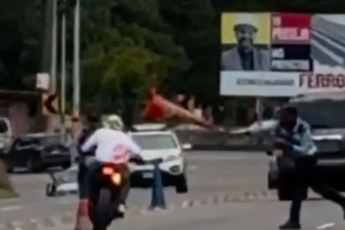 Momento en que agente de la Dirección Nacional de Vialidad y Transporte (DNVT) lanza un cono a un motociclista. Imagen: Captura de vídeo de ICN.