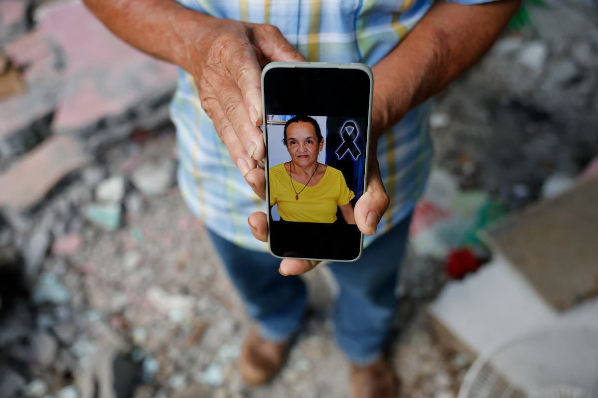 AME6193. MACARACAS (PANAMÁ), 14/10/2026.- Pedro Frías Castillo sostiene un teléfono con una fotografía de su esposa Elena Barría Vargas este miércoles, en su casa que fue afectada por el terremoto de magnitud 7,7, en Macaracas, provincia Los Santos (Panamá). Elena, de 68 años, falleció a causas del colapso de un muro en su vivienda y se convierte en la primera muerte oficial relacionada con este sismo que provocó cerca de una treintena de heridos. EFE/ Bienvenido Velasco