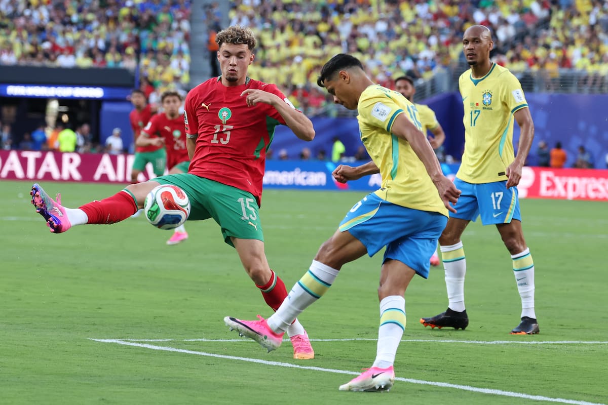 GR7145. NUEVA JERSEY (ESTADOS UNIDOS), 13/06/2026.- Douglas Santos (c) de Brasil disputa el balón con Samir El Mourabet (i) de Marruecos este sábado, durante un partido del grupo C del Mundial de la FIFA 2026 entre Brasil y Marruecos en el estadio MetLife en Nueva Jersey (Estados Unidos). EFE/ Sebastiao Moreira