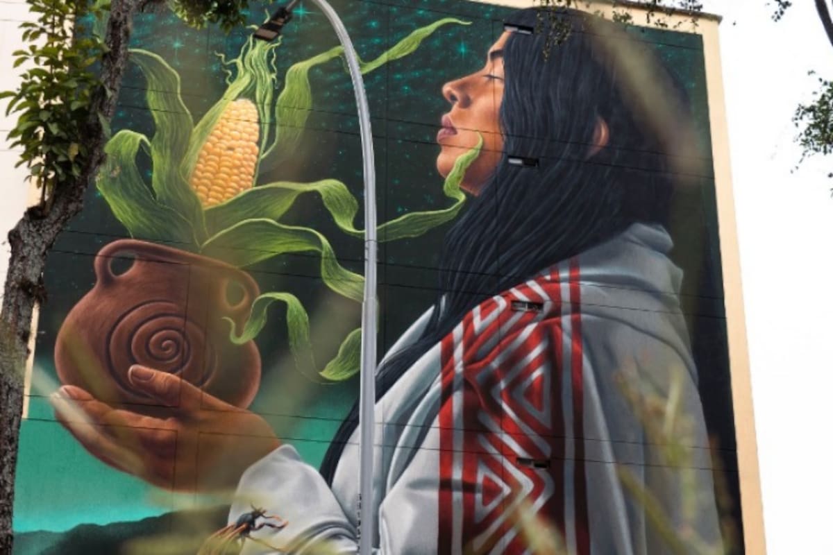La figura femenina del mural sostiene elementos que cuentan la historia de nuestros ancestros guanes: el cielo, la tierra y la comunidad en plena vida urbana de Bucaramanga. / Fotografías por Juan Ortega