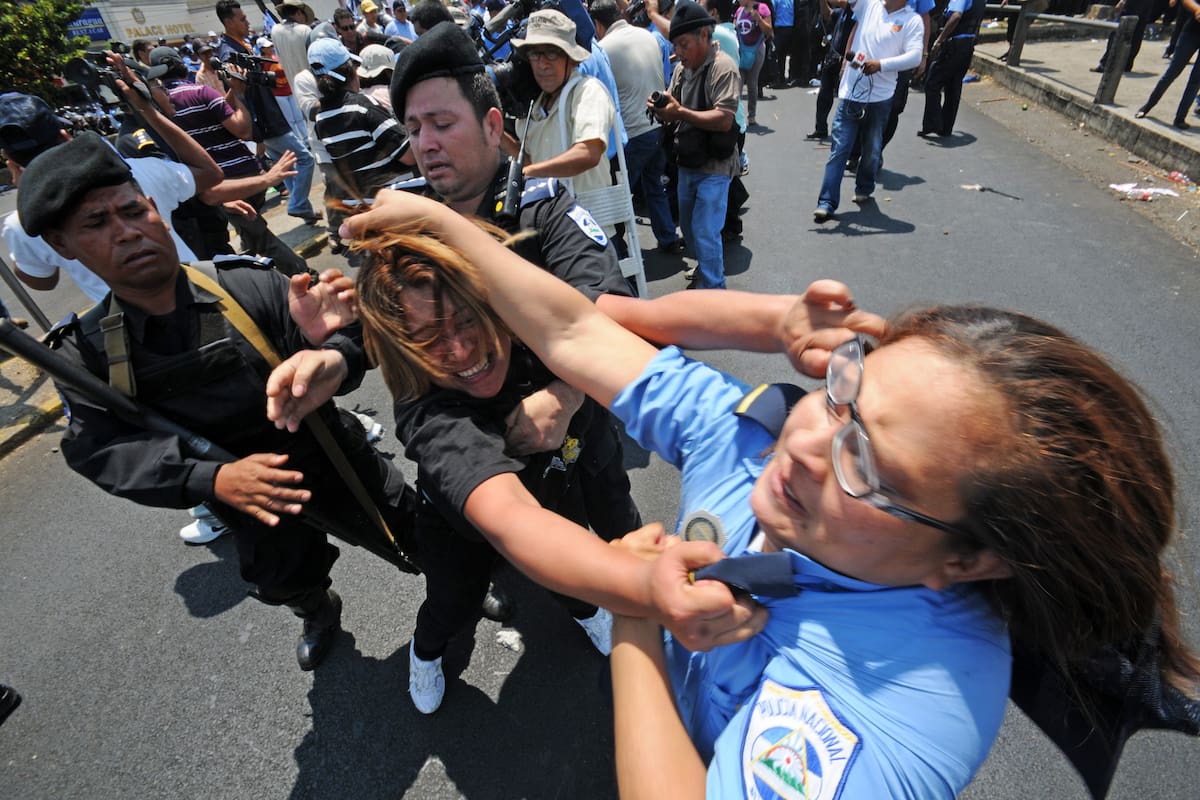 MAN08 - MANAGUA (NICARAGUA), 02/04/2011.- Una manifestante lucha con una agente de Policía antes de ser detenida hoy, sábado 2 de abril de 2011, en las calles de Managua (Nicaragua). Miles de seguidores y opositores del presidente nicaragüense, Daniel Ortega, se manifestaron por separado en la capital nicaragüense a favor y en contra de la posible reelección del gobernante sandinista en los comicios de noviembre próximo, en una jornada en la que resultaron al menos siete policías heridos y decenas de civiles golpeados. EFE/Mario López