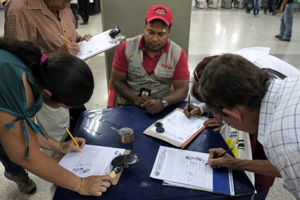 Un grupo de personas da su firma para la campaña “Recolección de firmas en contra de la injerencia de EU sobre Venezuela”, ayer en una estación del tren subterráneo en Caracas. (Foto: AFP / VANGUARDIA LIBERAL)