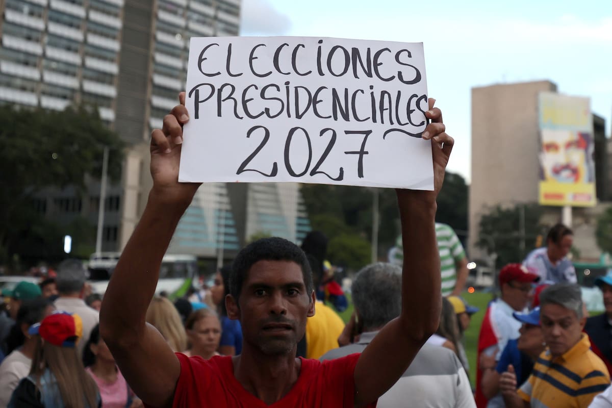 AME8729. CARACAS (VENEZUELA), 22/10/2026.- Una persona sostiene un cartel durante una manifestación de la oposición venezolana para exigir un cronograma electoral y comicios presidenciales para 2027, convocada por el partido Vente Venezuela (VV) este jueves, en Caracas (Venezuela). EFE/ Miguel Gutiérrez