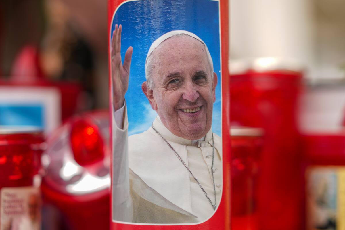 Se ven velas, una de ellas con la foto del Papa Francisco, frente al Policlínico Agostino Gemelli en Roma. //AP
