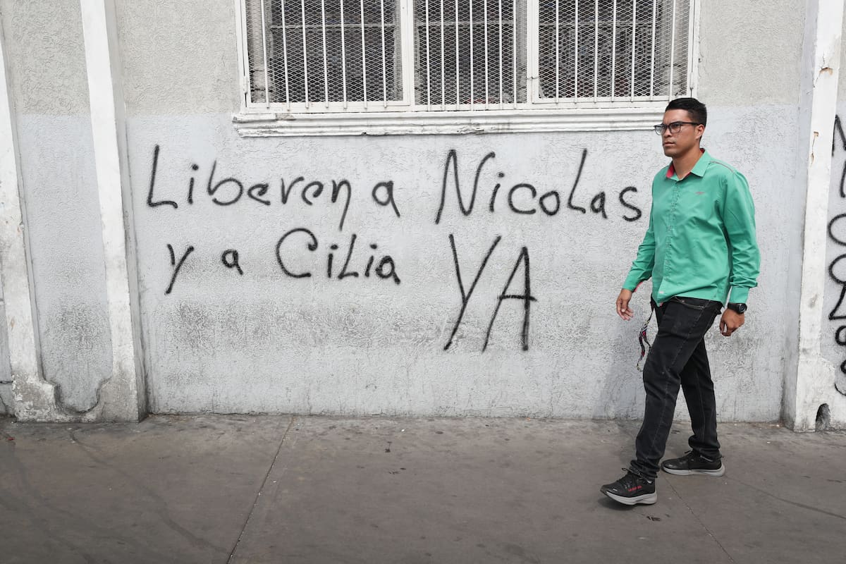 Una persona camina frente a un muro graffiteado durante una marcha en apoyo al inicio de la Asamblea Nacional este lunes, en Caracas (Venezuela). El Parlamento de Venezuela inició la legislatura 2026-2031 controlado nuevamente por el chavismo y con el regreso de algunas caras opositoras que se alejaron de la mayor coalición opositora del país, en una sesión marcada por la incertidumbre tras la captura del presidente Nicolás Maduro durante el ataque militar lanzado por Estados Unidos sobre varios puntos del territorio venezolano, entre ellos Caracas. EFE/ Ronald Peña R