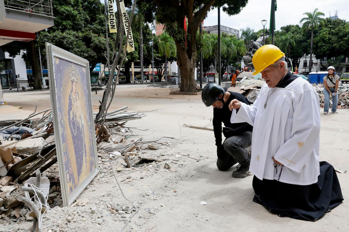 El padre Nelson Giraldo Mejía ora por las víctimas del terremoto de magnitud 7,4 ocurrido el pasado lunes, frente a los escombros del edificio Santiago Londoño, con una réplica de la Virgen de Nuestra Señora de la Pobreza, este viernes en Pereira. EFE/ Carlos Ortega
