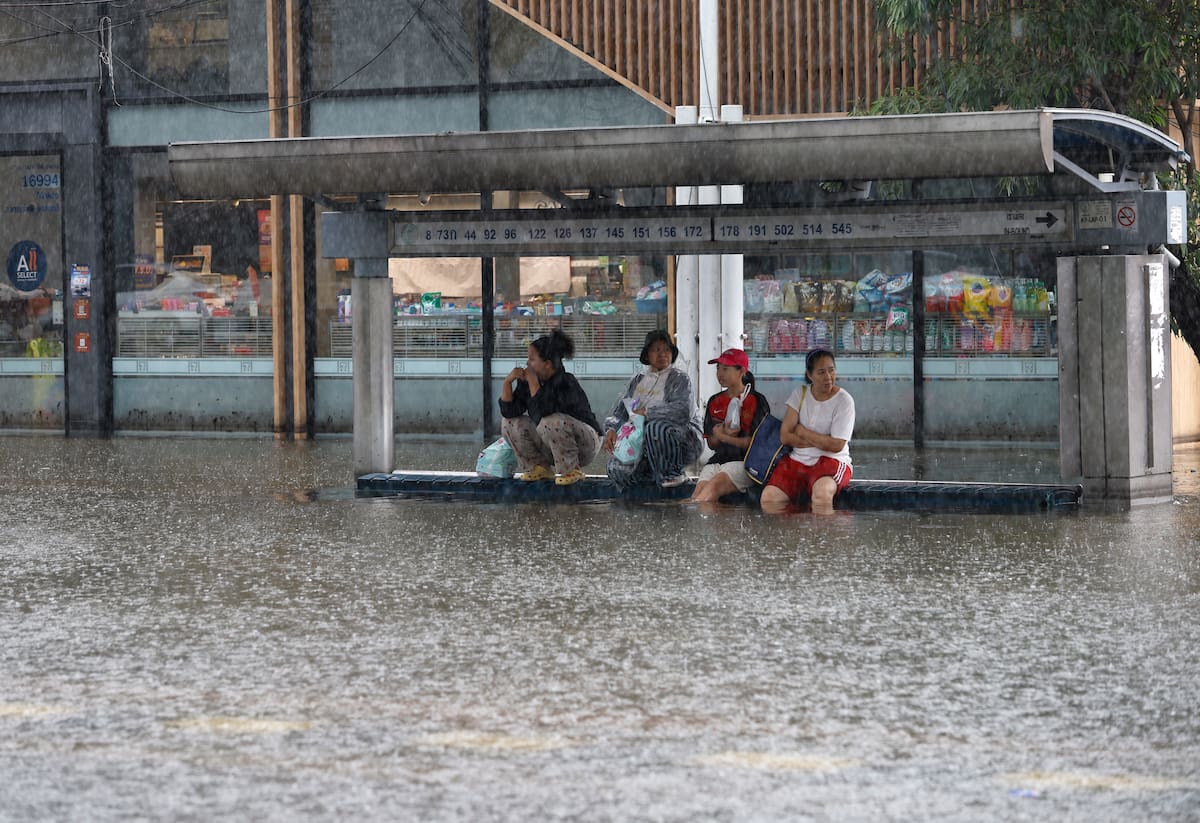 Residentes tailandeses esperan un camión para trasladarse durante un fuerte aguacero en el distrito inundado de Bangkapi, en la capitalina Bangkok, declarada zona de desastre por inundaciones tras persistentes y fuertes lluvias. EFE/EPA/RUNGROJ YONGRIT