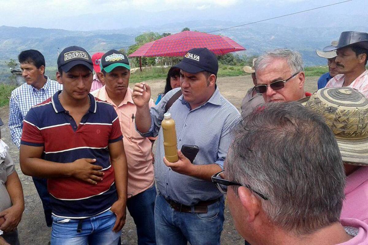 El alcalde de Guapotá, Nelson Lamus, sostiene una botella de agua contaminada, debido al represamiento y remoción de tierras, en las veredas Gualilo y Cabras, donde se adelanta la construcción de unos galpones de la Empresa Pollos El Dorado. (Foto: Suministada/VANGUARDIA LIBERAL)