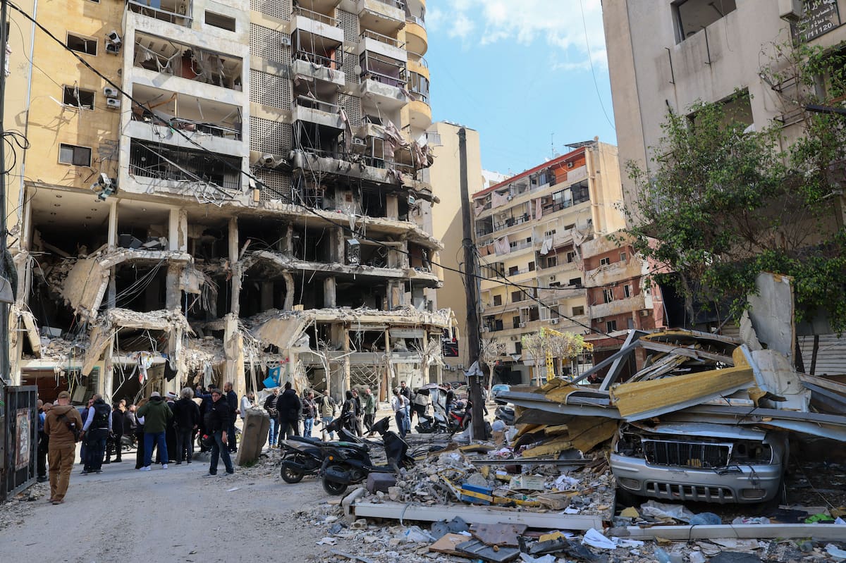 BEIRUT (Lebanon), 20/04/2026.- A group of people walk next to a partially damaged building targeted by an Israeli air strike during a press tour organised by the Hezbollah media office in Bir al-Abed, in the southern suburbs of Beirut, Lebanon, 20 April 2026. Israel and Lebanon have agreed to a 10-day ceasefire, which went into effect at midnight on 16 April. (Líbano, Hizbulá/Hezbolá) EFE/EPA/WAEL HAMZEH
