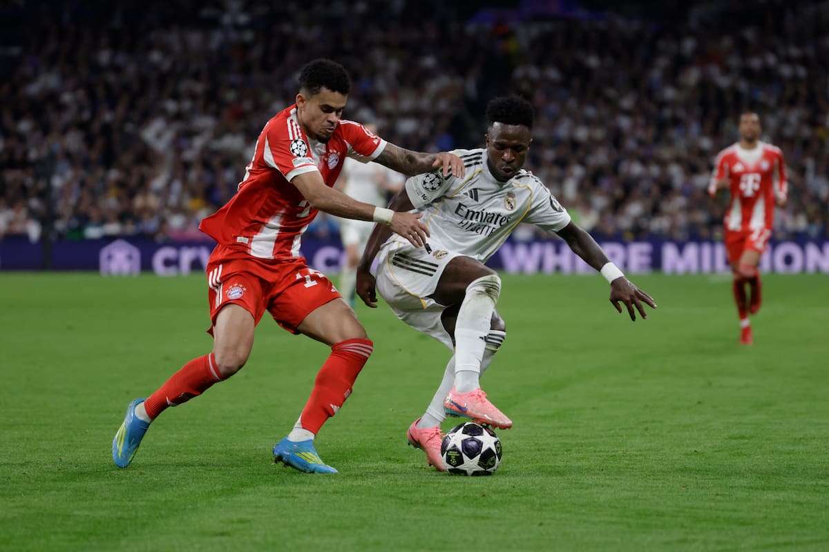 MADRID, 07/04/2026.- El delantero del Real Madrid Vinicius Jr. (d) lucha con Luis Díaz, del Bayern Munich, durante el encuentro correspondiente a la ida de los cuartos de final de la Liga de Campeones que disputan este martes Real Madrid y Bayern Munich en el estadio Santiago Bernabéu, en Madrid. EFE/Juanjo Martín