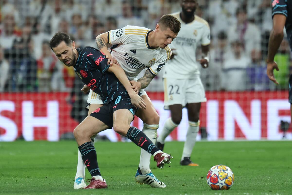MADRID, 09/04/2024.- El delantero del Manchester Bernardo Silva (i) pelea un balón con Toni Kroos, del Real Madrid, durante el partido de ida de cuartos de final de la Liga de Campeones que Real Madrid y Manchester City disputan este martes en el estadio Santiago Bernabéu. EFE/Kiko Huesca