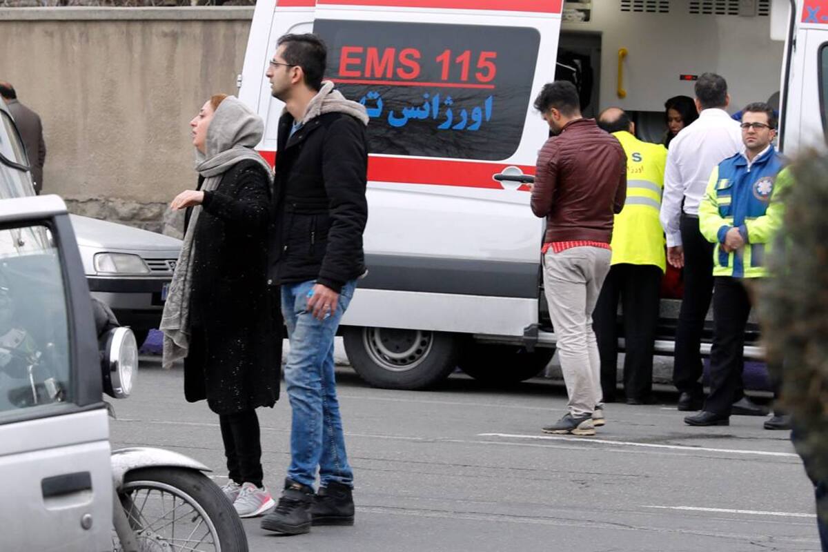 Auxiliares de emergencia iraníes acompañan a familiares de pasajeros de un vuelo de la aerolínea Aseman que se estrelló. (Foto: EFE/VANGUARDIA LIBERAL )