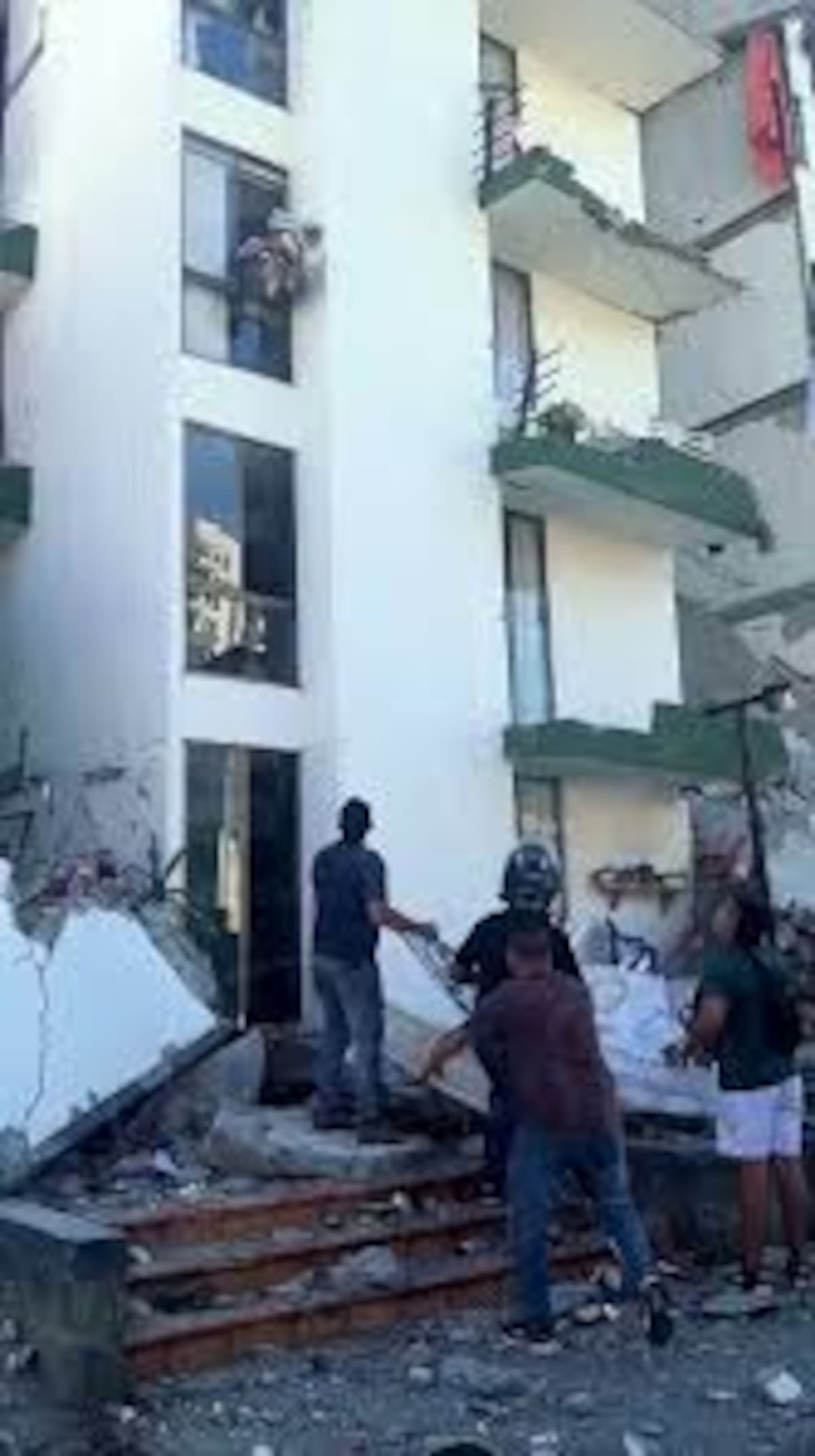 Rescatistas y ciudadanos reciben a un perrito que fue sacado con vida de una estructura afectada por el terremoto en Pereira.