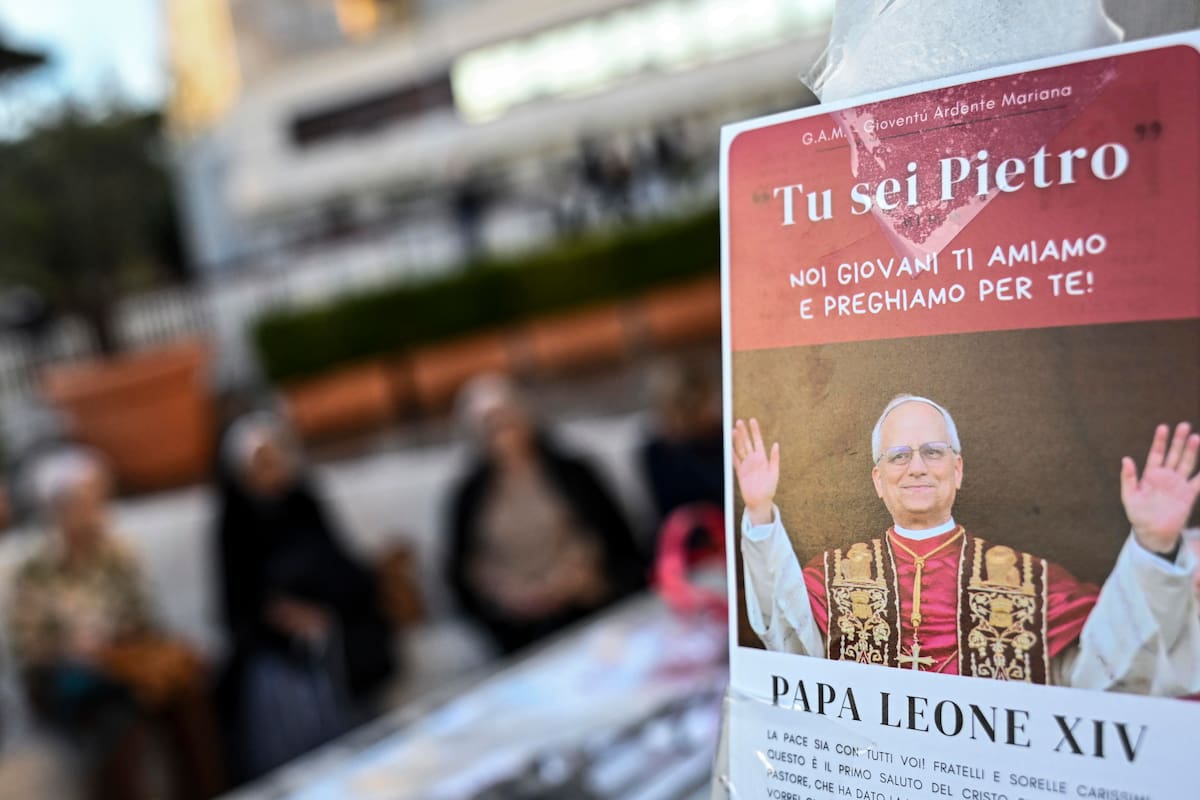 Una estampa del papa León al pie de la estatua del papa Juan Pablo II frente al Hospital Universitario Agostino Gemelli, donde el papa León XIV se encuentra hospitalizado en Roma, Italia, el 15 de octubre de 2026. Según la Oficina de Prensa de la Santa Sede, el papa León XIV se recupera en el hospital tras una exitosa cirugía torácica realizada el 13 de octubre para extirparle el lóbulo inferior del pulmón derecho, durante la cual los médicos confirmaron el diagnóstico de adenocarcinoma de pulmón.