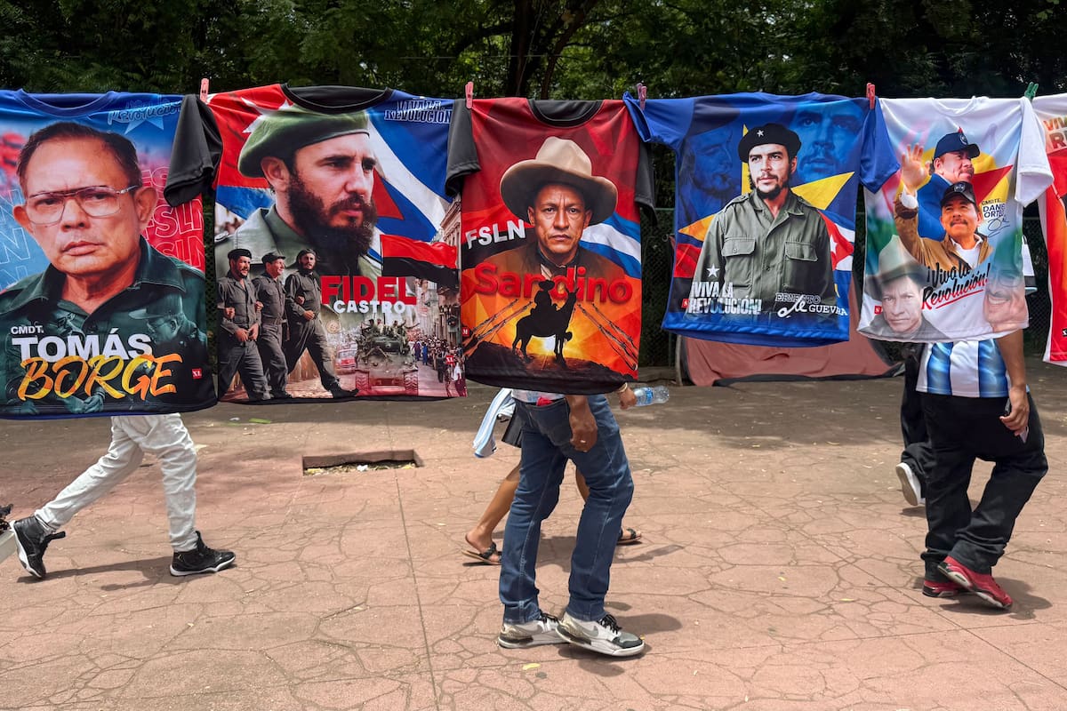 Personas caminan detrás de camisetas estampadas con la imagen de varios líderes políticos de la izquierda latinoamericana durante la celebración del 47 aniversario de la revolución que derrocó por la vía armada a la dictadura de Anastasio Somoza Debayle, este domingo, en Managua (Nicaragua). EFE/ STR
