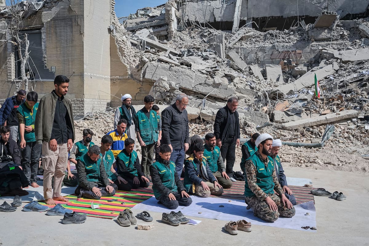 TEHERÁN (IRÁN), 04/03/2026.- Un grupo de voluntarios basijis -milicia islámica- reza este miércoles, al lado de un edificio destruido en los bombardeos israelíes-estadounidenses contra Irán en la calle en la calle Kargar, cerca de la plaza Engelab en Teherán. Según la Agencia de Noticias de Activistas de Derechos Humanos (HRANA), con sede en Estados Unidos, al menos 1.097 civiles han muerto en Irán desde el inicio de la guerra, incluidos 181 niños menores de 10 años. EFE/ Jaime León