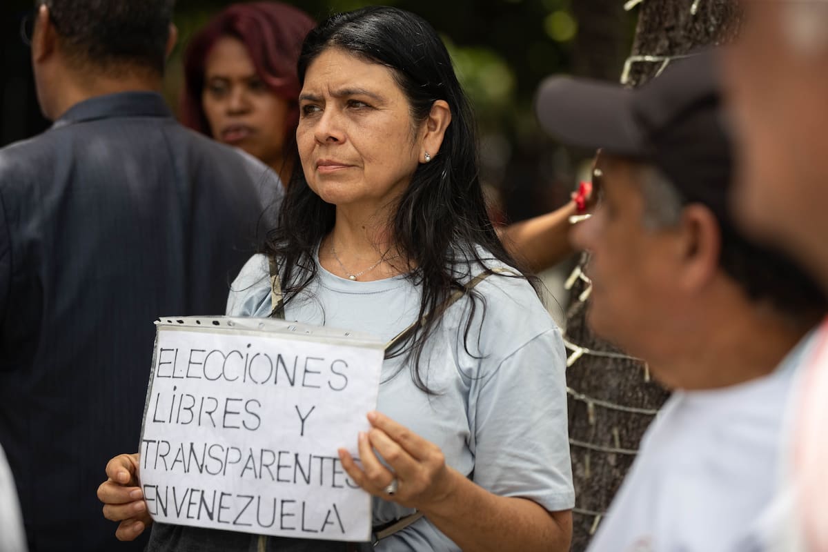 AME5599. CARACAS (VENEZUELA), 03/08/2026.- Una persona sostiene un cartel durante una manifestación para exigir que se celebren elecciones presidenciales este año en el país suramericano, al cumplirse siete meses de la captura de Nicolás Maduro por parte de tropas estadounidenses, este lunes, en Caracas (Venezuela). EFE/ Ronald Peña R