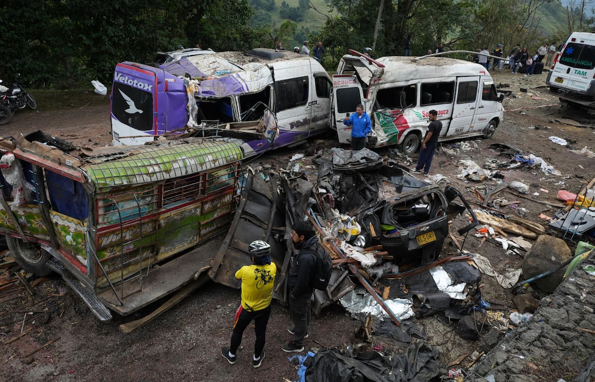 CAJIBÍO (COLOMBIA) Personas observan este domingo vehículos destruidos por un atentado ocurrido en la Vía Panamericana en Cajibío (Colombia). El número de personas muertas por el ataque guerrillero de este sábado con un cilindro bomba en la Vía Panamericana, en el suroeste de Colombia, subió a 19, todos civiles. EFE/Ernesto Guzmán