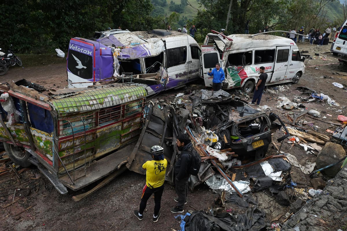 CAJIBÍO (COLOMBIA) Personas observan este domingo vehículos destruidos por un atentado ocurrido en la Vía Panamericana en Cajibío (Colombia). El número de personas muertas por el ataque guerrillero de este sábado con un cilindro bomba en la Vía Panamericana, en el suroeste de Colombia, subió a 19, todos civiles. EFE/Ernesto Guzmán