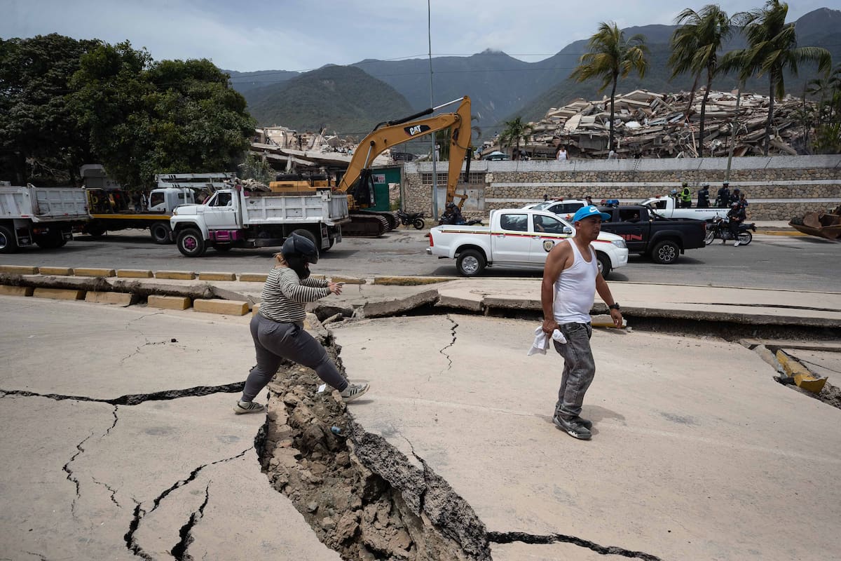 AME4344. LA GUAIRA (VENEZUELA), 25/06/2026.- Personas caminan entre las grietas este jueves, que dejaron los terremotos en La Guaira (Venezuela). El número de fallecidos en Venezuela a causa de los dos terremotos del miércoles se elevó a 188 y el de heridos a 1.520, mientras que al menos 346 construcciones, entre edificios, hospitales y centros comerciales, resultaron afectadas, informó el presidente de la Asamblea Nacional (AN, Parlamento), el chavista Jorge Rodríguez. EFE/ Ronald Peña R.
