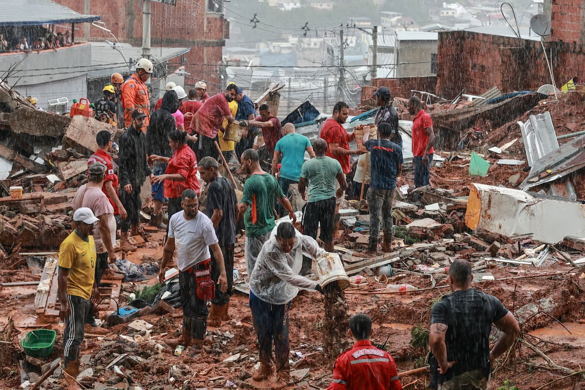 AME7991. JUIZ DE FORA (BRASIL), 24/02/2026.- Personas ayudan en labores de rescate y remoción de escombros en una zona afectada por fuertes lluvias este martes, en Juiz de Fora (Brasil). Al menos 16 personas murieron en Juiz de Fora, la segunda mayor ciudad de Minas Gerais, y otras 7 en Ubá, en su mayoría por deslizamientos de tierras y desplomes de edificaciones, de acuerdo con un nuevo balance del Cuerpo de Bomberos. EFE/ Andre Coelho