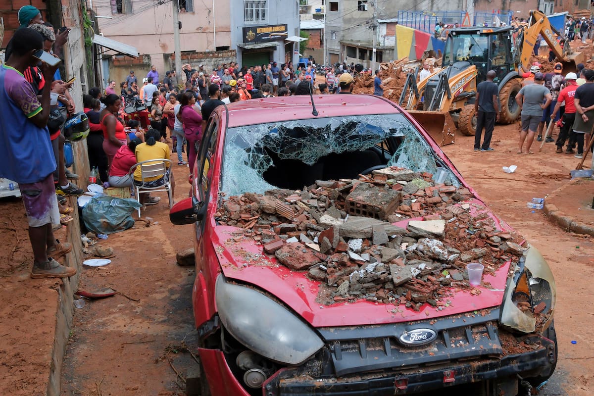 Integrantes del equipo de Bomberos encuentran un cuerpo sin vida durante las labores de rescate en una zona afectada por fuertes lluvias este martes, en Juiz de Fora (Brasil). | EFE