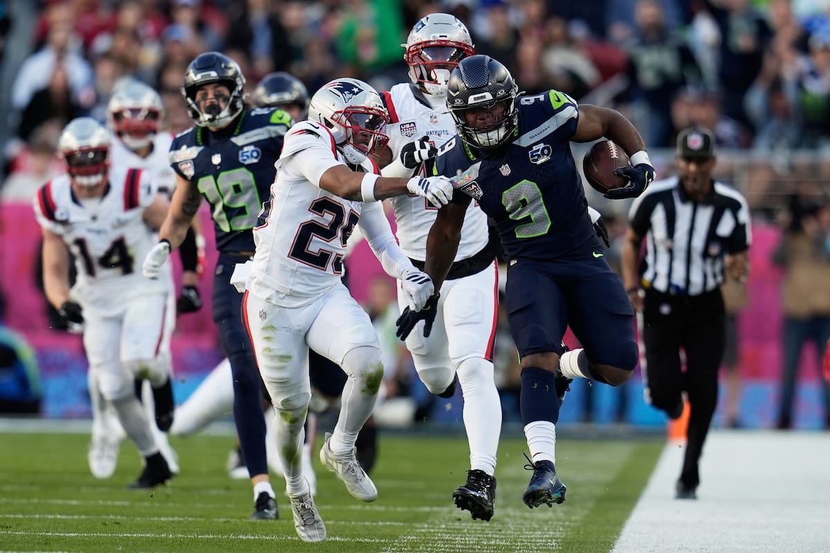 El corredor de los Seattle Seahawks, Kenneth Walker III (9), corre contra el esquinero de los New England Patriots, Marcus Jones (25), durante la primera mitad del partido de fútbol americano Super Bowl 60 de la NFL. //Foto, AP: Steve Luciano