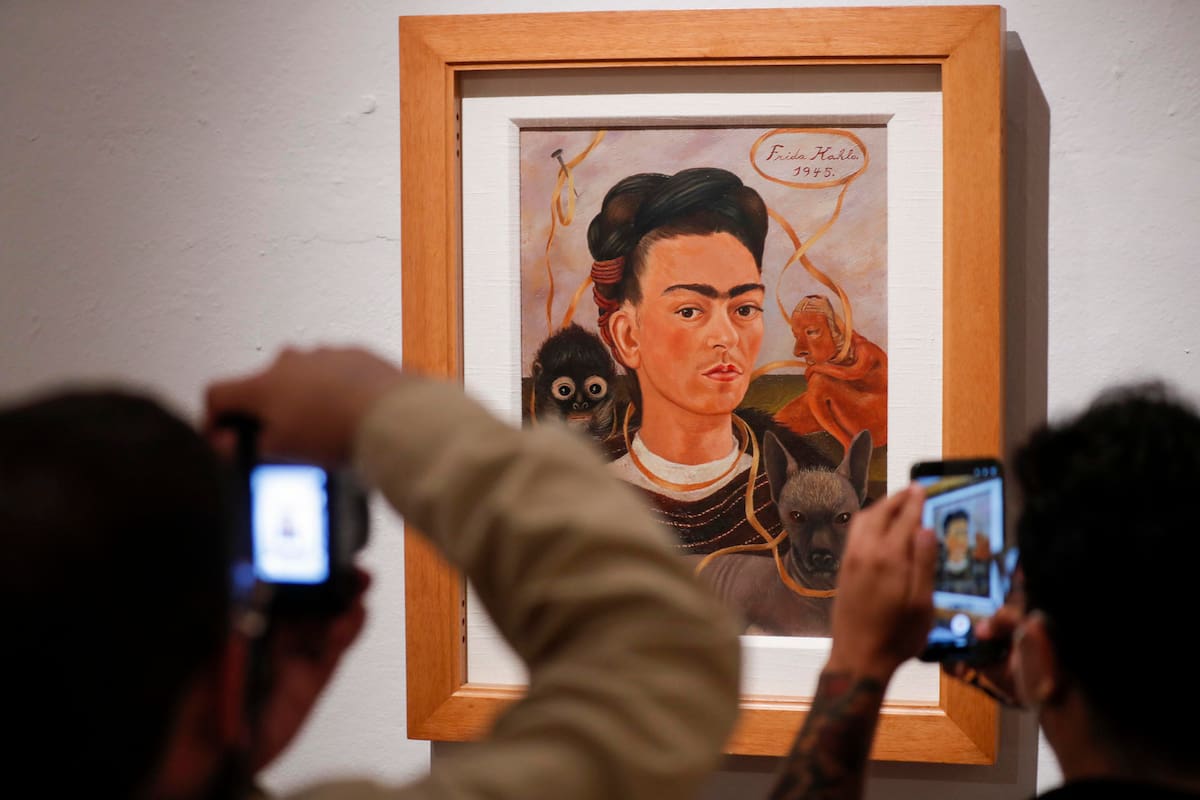 Fotografía del 29 de mayo de 2026 de personas tomando fotografías de la obra 'Autorretrato con mono' de Frida Kahlo durante un recorrido en el Museo Dolores Olmedo en Ciudad de México (México). EFE/Isaac Esquivel