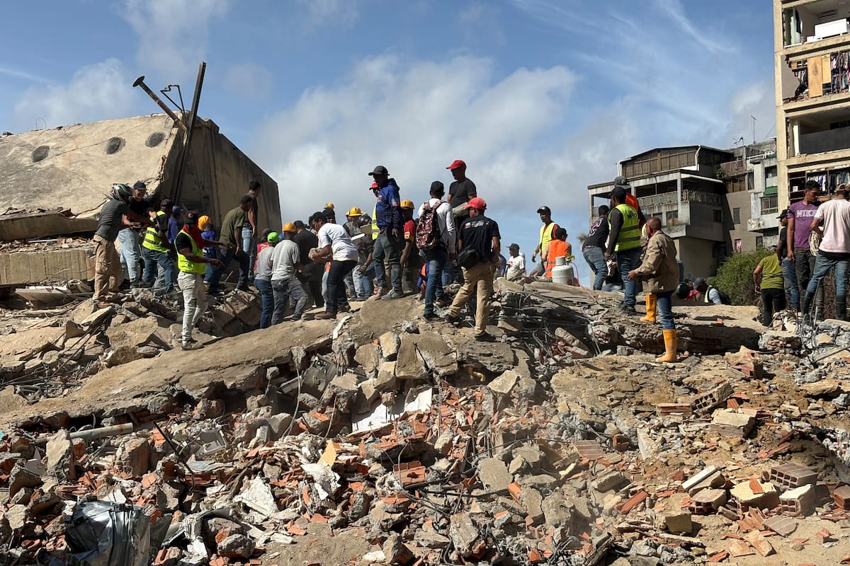 Personas caminan sobre escombros de edificios derrumbados por los terremotos este jueves, en el sector San Bernardino, en Caracas (Venezuela). EFE/ Carlos Seijas.