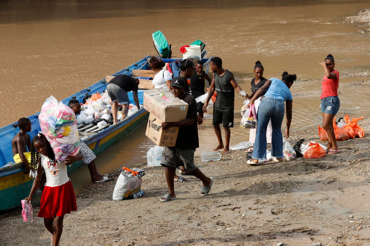 Personas descargan ayudas humanitarias por el terremoto de magnitud 7,4 del pasado lunes, en el río San Juan en La Encharca. Seis días después del terremoto, La Encharca, una remota comunidad ubicada a orillas del río Suruco, en el municipio chocoano de Medio San Juan, muestra otra cara de la emergencia en Colombia: la de quienes viven lejos de los centros urbanos y afrontan las consecuencias del sismo sin servicios básicos y bajo la presión de grupos armados ilegales. EFE/ Mauricio Dueñas Castañeda