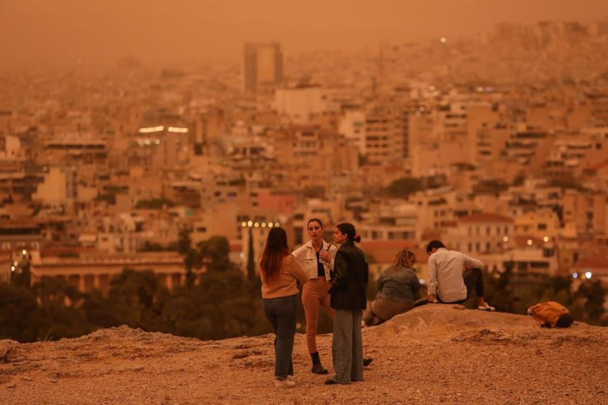 La gente pasea por la zona de Acrópolis mientras el polvo africano cubre el cielo de Atenas.