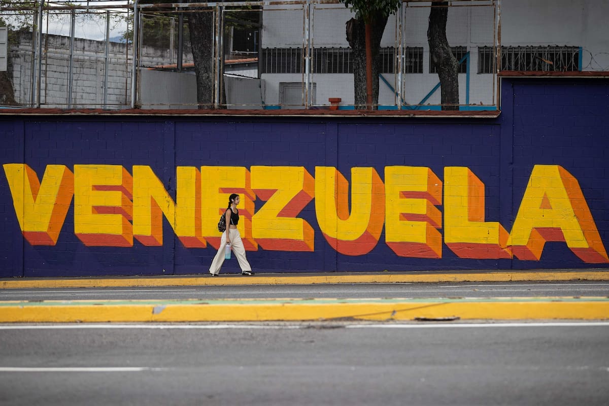 AME7978. CARACAS (VENEZUELA), 03/06/2026.- Fotografía del 31 de mayo del 2026 que muestra a una persona caminando frente a un mural de Venezuela, en Caracas (Venezuela). Con un dólar que sube a diario, protestas semanales por salarios y un chavismo que retiene el control gubernamental, Venezuela cumple cinco meses sin Nicolás Maduro y una realidad que para muchos no ha cambiado, pese a la operación militar que sacó del poder al líder chavista y que en opinión de Donald Trump ha traído alegría a los venezolanos. EFE/ Ronald Peña R