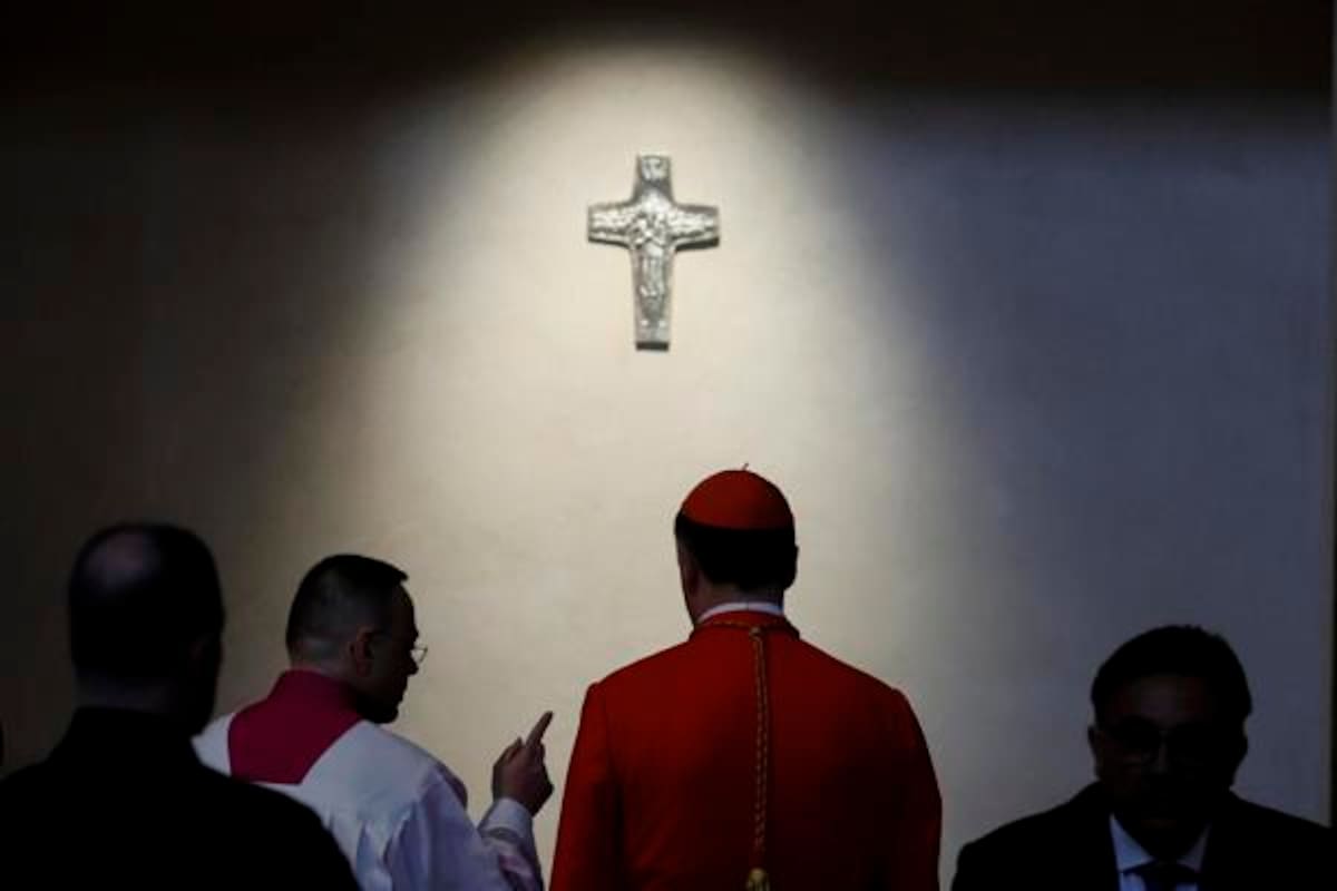 El cardenal Rolandas Makrickas (2R) se encuentra frente a la tumba del Papa Francisco antes de una santa misa en el primer aniversario de su muerte.