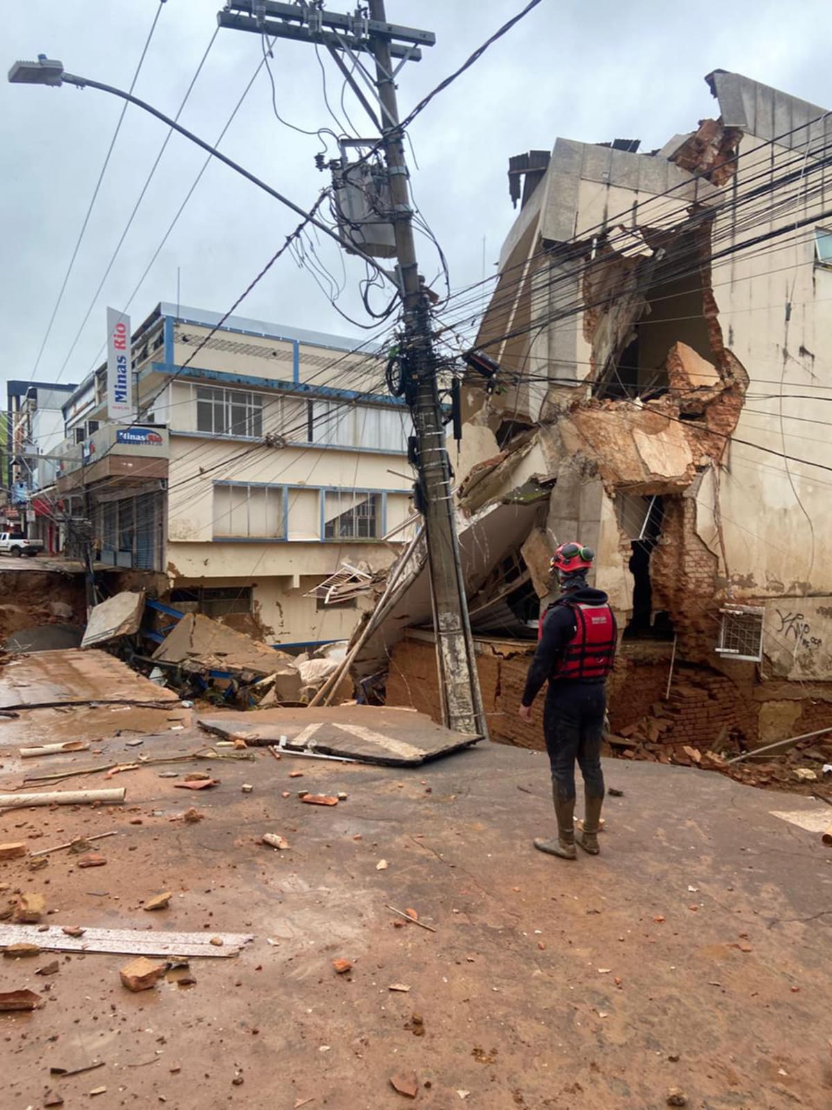 Integrantes del equipo de Bomberos encuentran un cuerpo sin vida durante las labores de rescate en una zona afectada por fuertes lluvias este martes, en Juiz de Fora (Brasil). Un fuerte temporal ha dejado al menos 31 muertos y 38 desaparecidos en dos municipios del estado brasileño. | Foto: EFE