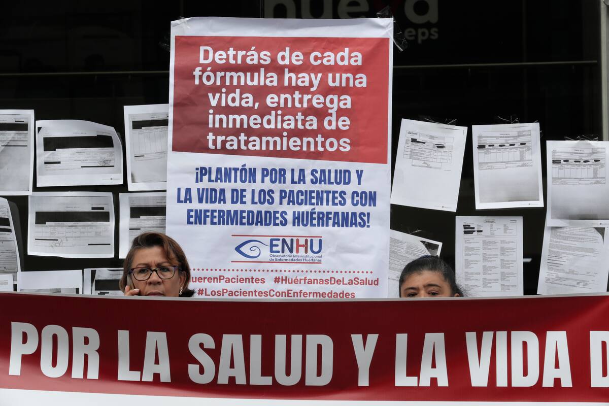 Fotografía de archivo del 28 de enero de 2026 que muestra a dos personas durante una protesta contra la atención en salud en Bogotá (Colombia).