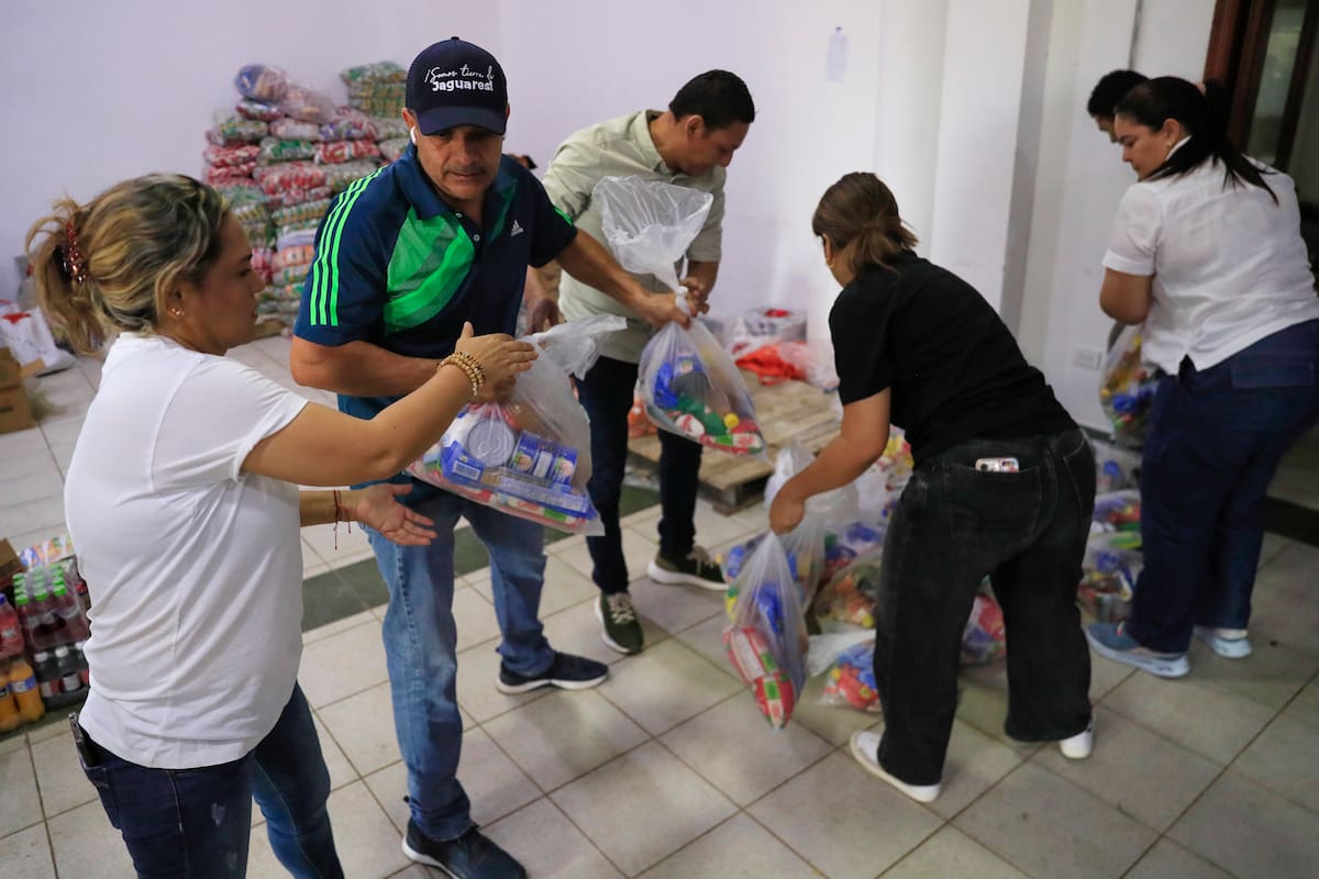 Fotografía del 7 de febrero de 2026 de un grupo de voluntarios sosteniendo bolsas con ayuda alimentaria para los damnificados de las inundaciones en Montería (Colombia). Más de 100 toneladas de ayudas humanitarias han sido recolectadas en la última semana en Montería para atender a las comunidades afectadas por las inundaciones en el departamento de Córdoba, noroeste de Colombia. EFE/ Carlos Ortega