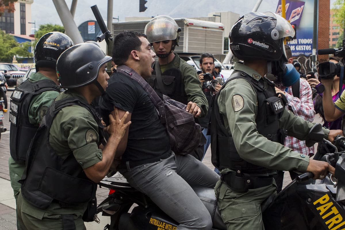 CAR13. CARACAS (VENEZUELA), 12/05/2014.- Miembros de la Guardia Nacional Bolivariana detienen a un manifestante durante una marcha de opositores hoy, lunes 12 de mayo de 2014, en el sector Las Mercedes, de Caracas (Venezuela). La Policía Nacional Bolivariana (PNB) y la Guardia Nacional (GNB, policía militarizada) impidieron a varios centenares de manifestantes marchar por Caracas, mientras miembros del movimiento estudiantil exigieron la liberación de los detenidos y convocaron a nuevas protestas. EFE/Miguel Gutiérrez
