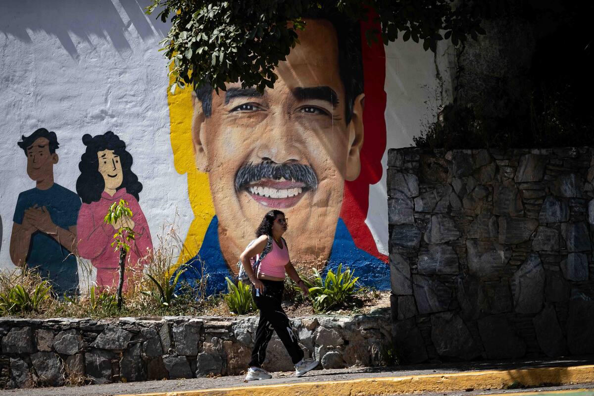 Una persona camina frente a un mural con la imagen de Nicolás Maduro este jueves, en Caracas (Venezuela). EFE/ Ronald Peña R