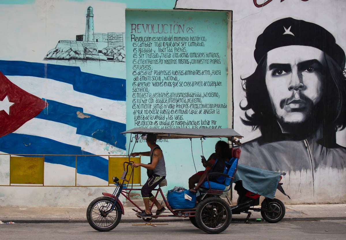Un bicitaxi es visto transitando al frente de la imagen del guerrillero Ernesto ?Che "Guevara" y la bandera cubana, hoy en La Habana, (Cuba). EFE/ Yander Zamora