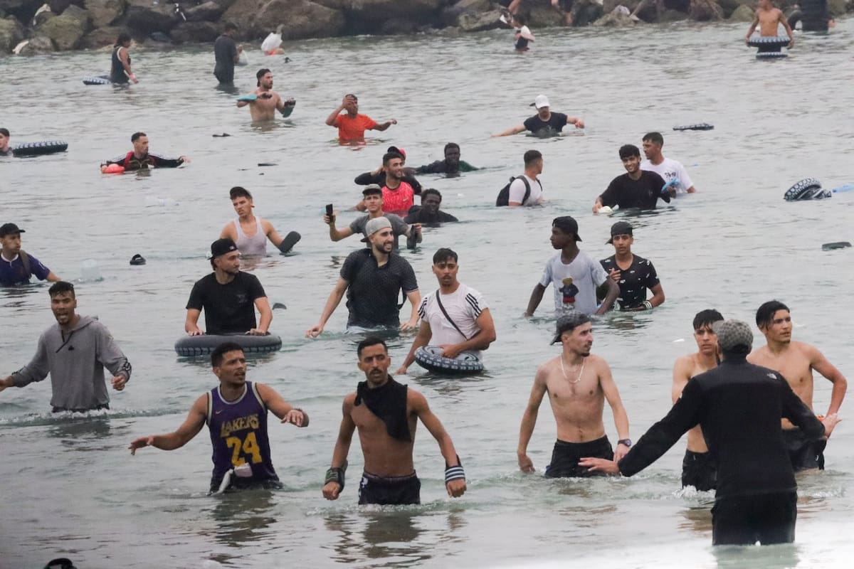 FOTODELDIA CEUTA (ESPAÑA), 31/07/2026.- Un grupo de inmigrantes en la playa junto al paso fronterizo del Tarajal en Ceuta este viernes, donde se han registrado violentos enfrentamientos en los perímetros fronterizos durante su intento de acceder desde Marruecos hacia Ceuta y Melilla. EFE/ Reduan Dris